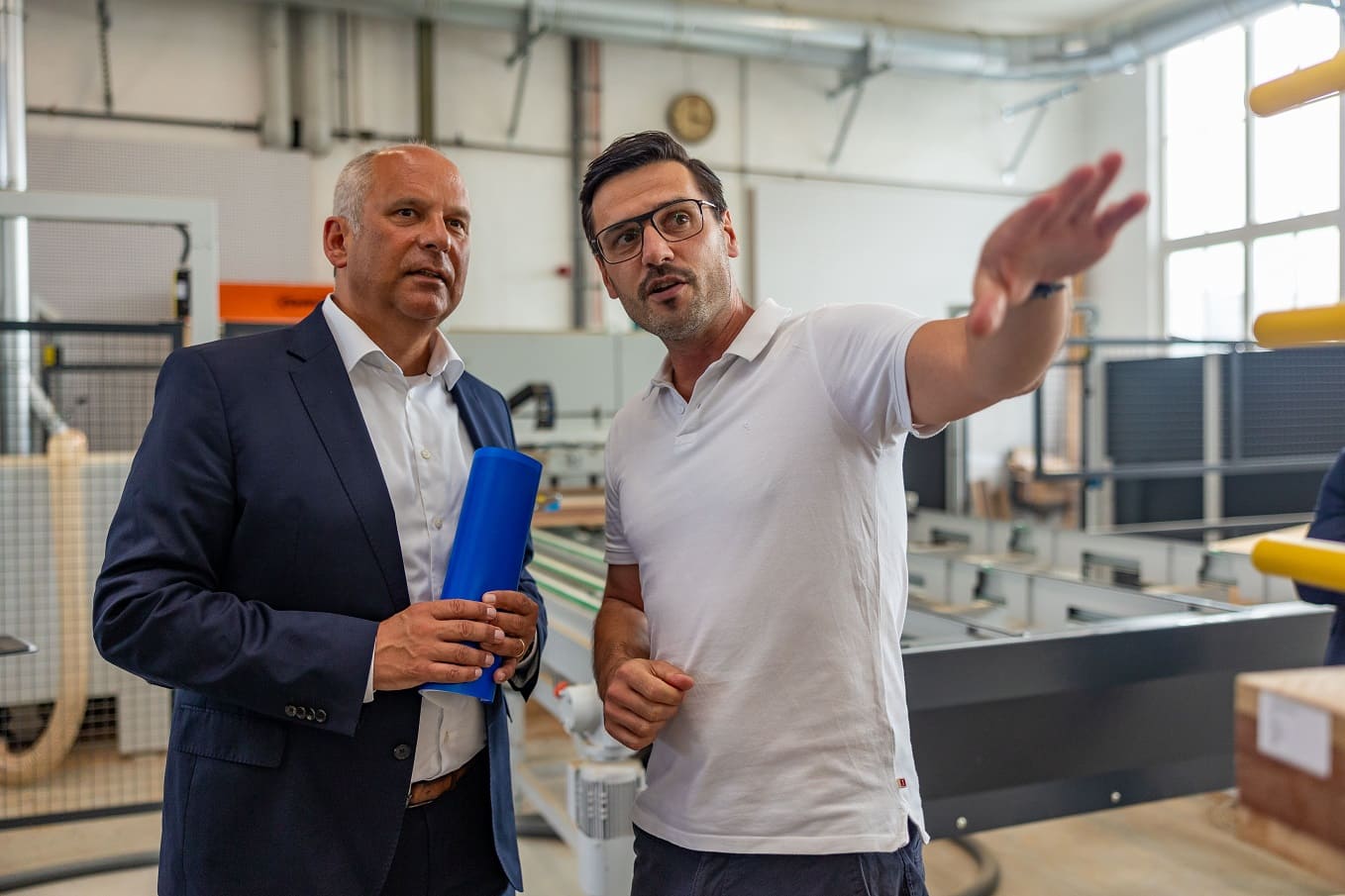 Mike Holzhausen erklärt Innenminister Poseck einen Produktionsschritt 